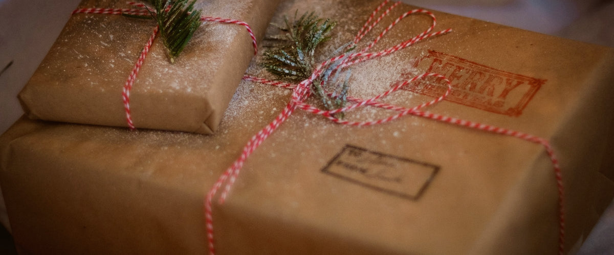 Holiday gifts wrapped in kraft paper with pine sprigs